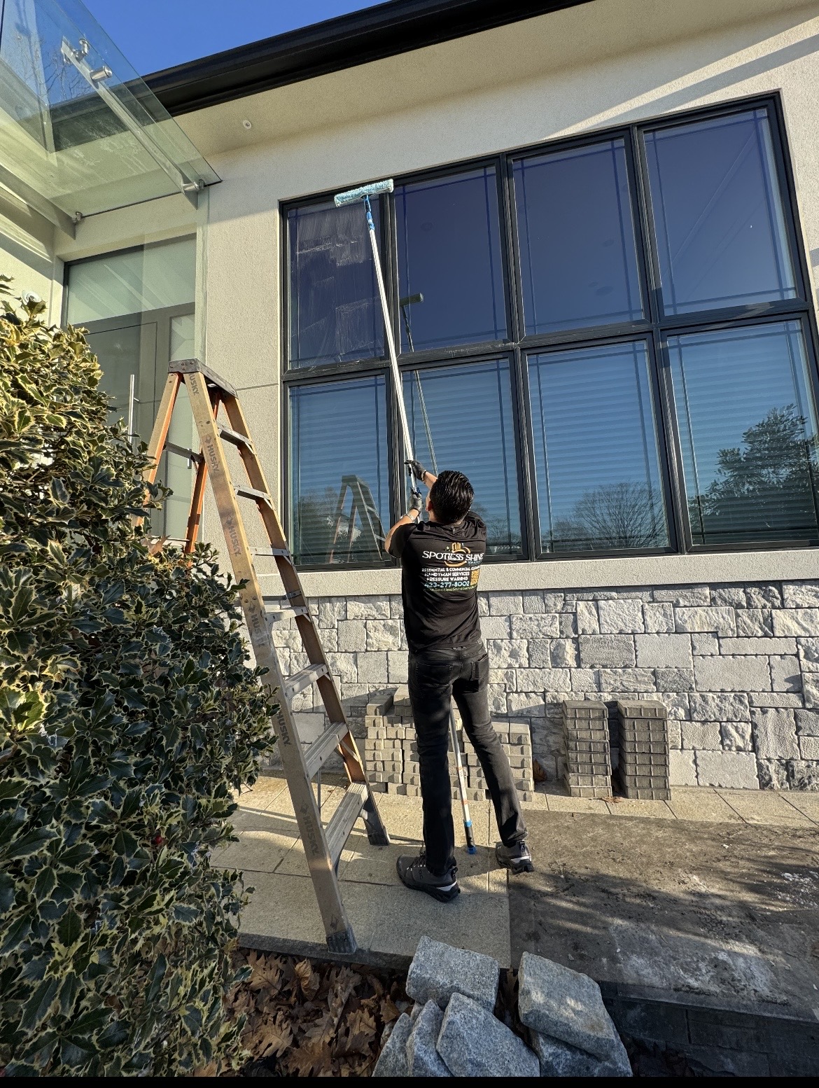 Technician washing exterior windows with a water-fed pole