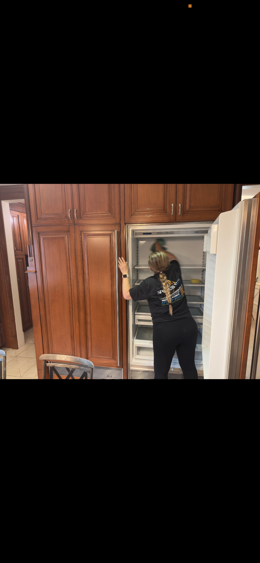Cleaner detailing the interior of a built-in refrigerator