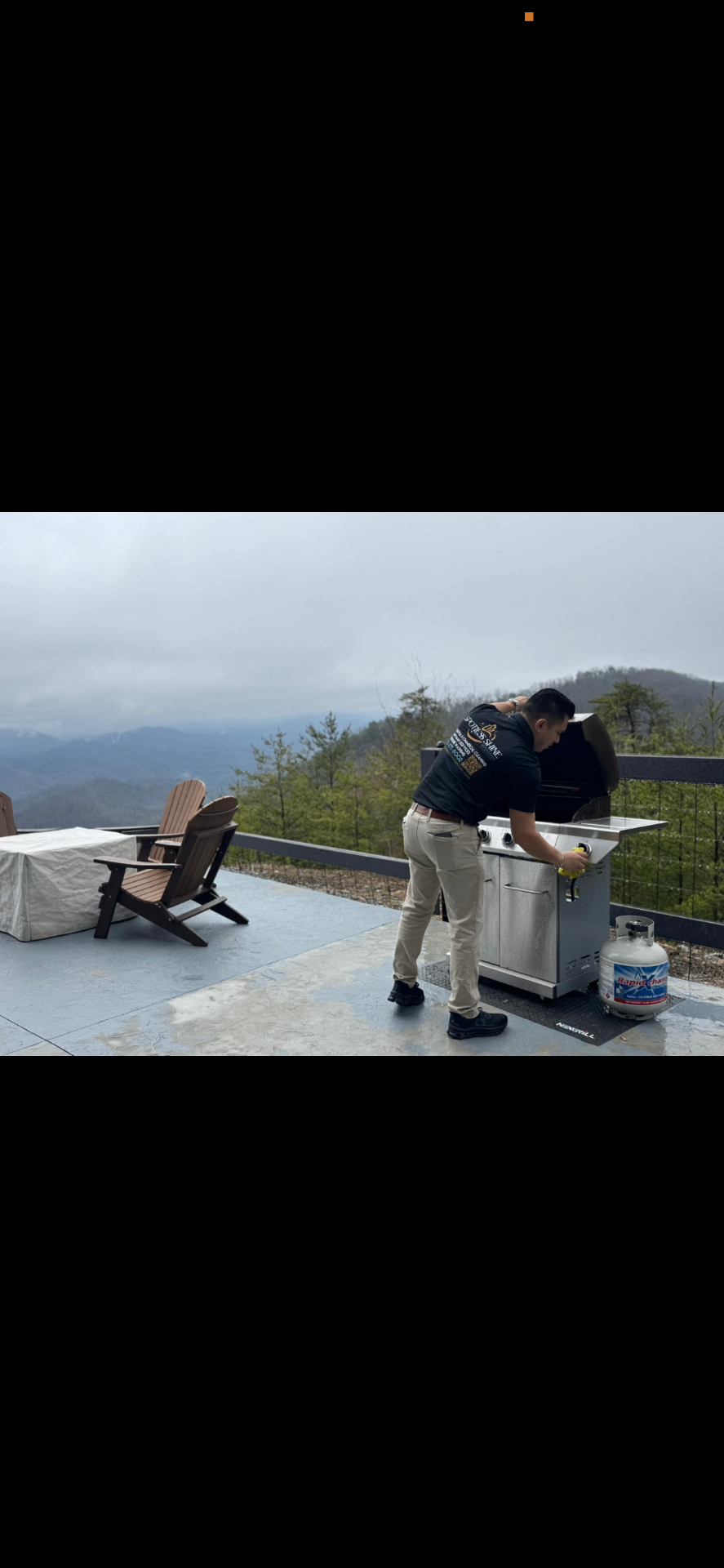 Spotless Shine technician cleaning an outdoor grill on a mountain-view deck
